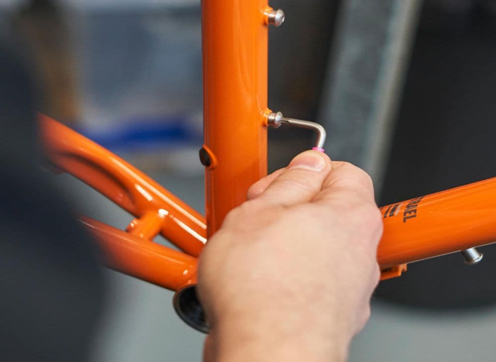 A close up shot of a bicycle being assembled.