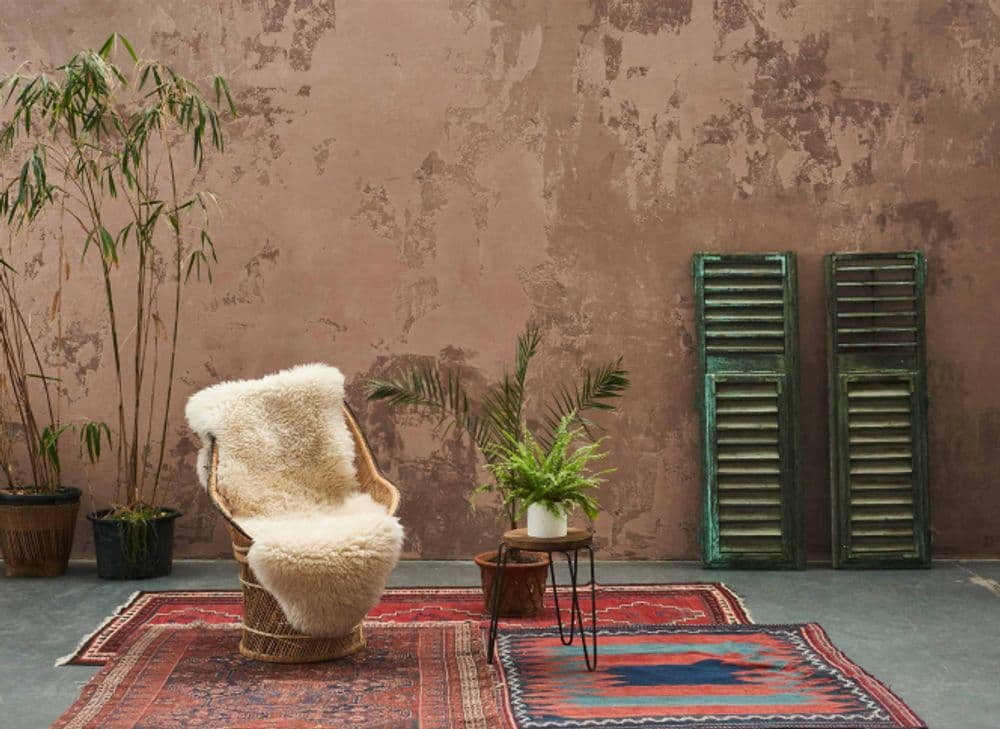 Moroccan carpets, terracotta walls, wooden window shutters with green paint peeling away from the wood.
